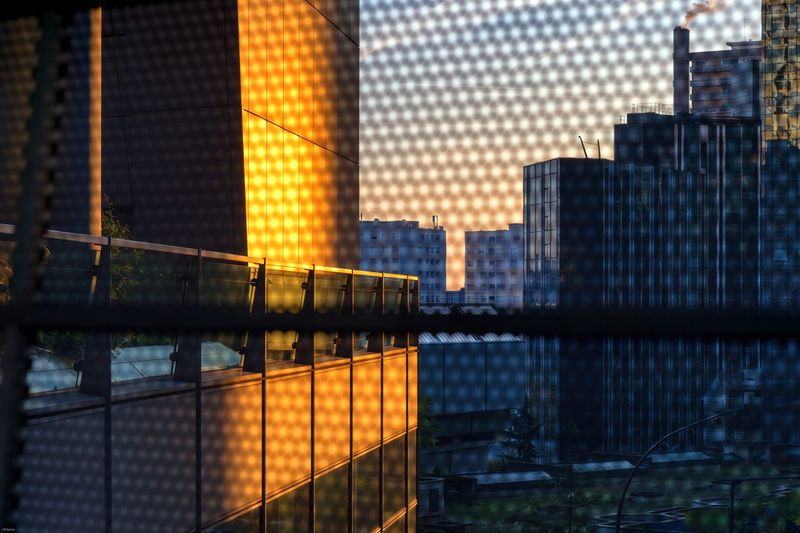 Reflection of buildings in city at sunset
