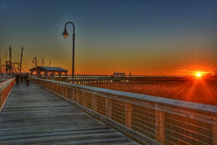 Pier on sea at sunset