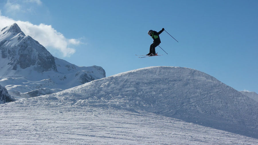 Low angle view of person skiing against cloudy sky