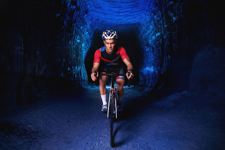 Portrait of man riding bicycle in tunnel