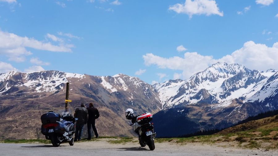 Rear view of men and motorcycles against mountains during winter