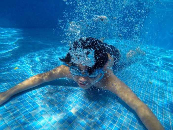 Shirtless boy swimming in pool