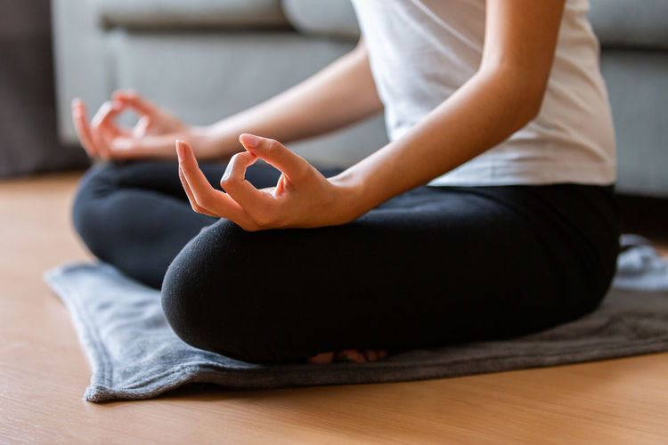 Low section of woman doing yoga at home