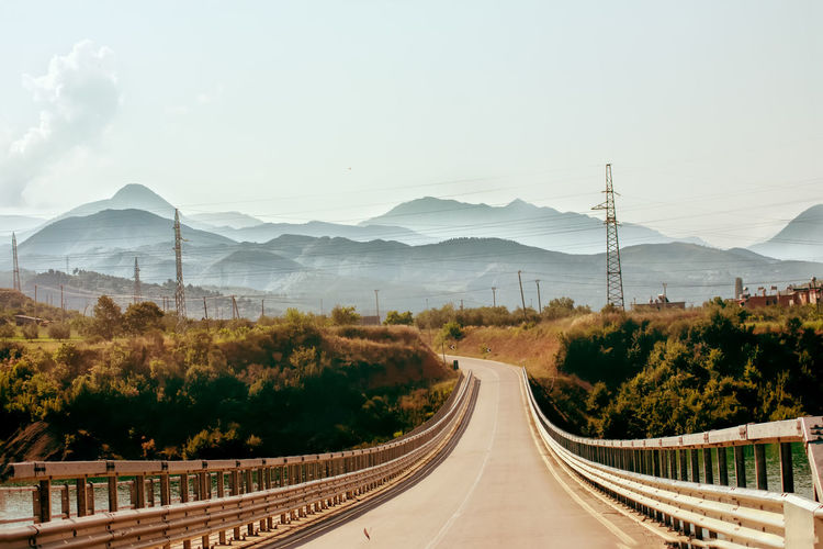 Panoramic view of road leading towards mountains against sky