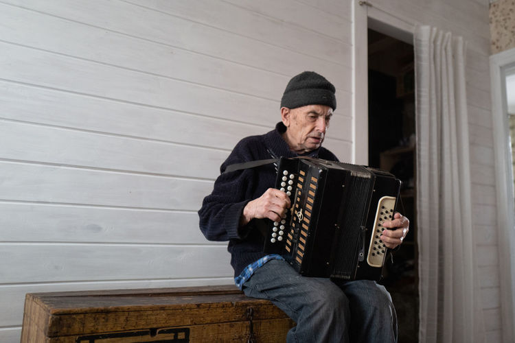 Old man playing harmonica