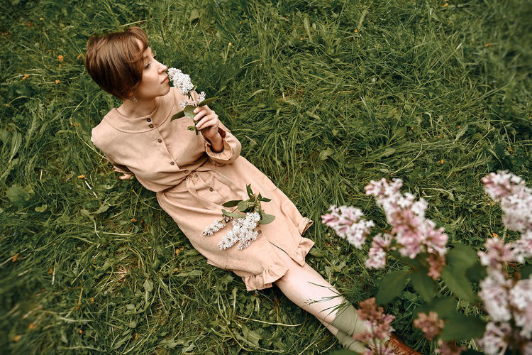 High angle view of woman lying on grassy field