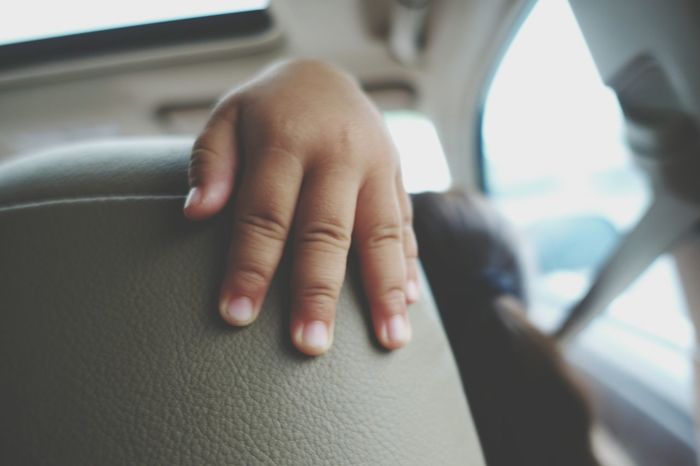 Cropped hand on car seat