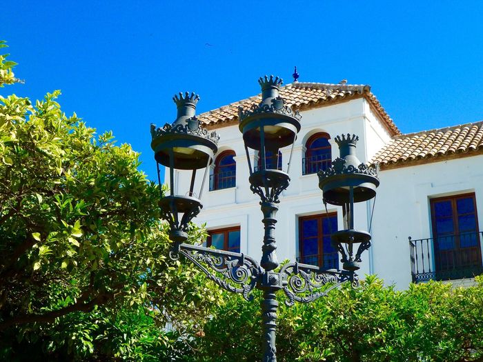 Low angle view of lamp post and house against clear blue sky