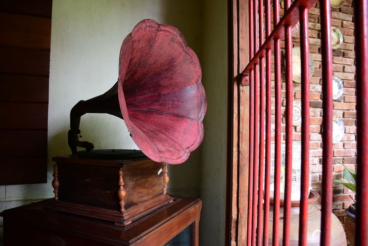 Red gramophone by security bars of window at home
