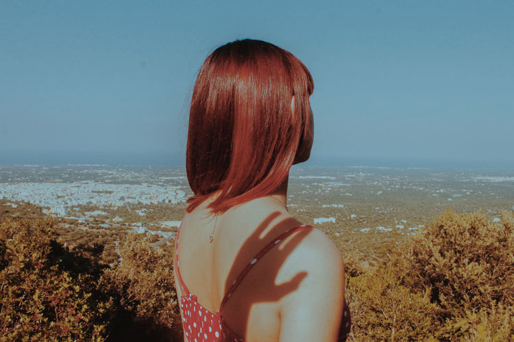 Rear view of woman looking at sea against sky