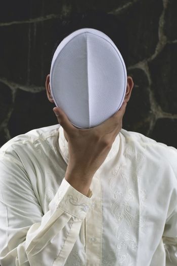 FULL LENGTH PORTRAIT OF MAN HOLDING HAT WHILE