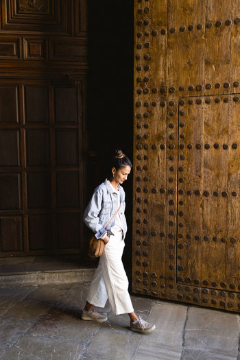 A young woman walks out of a church in granada historical quarter