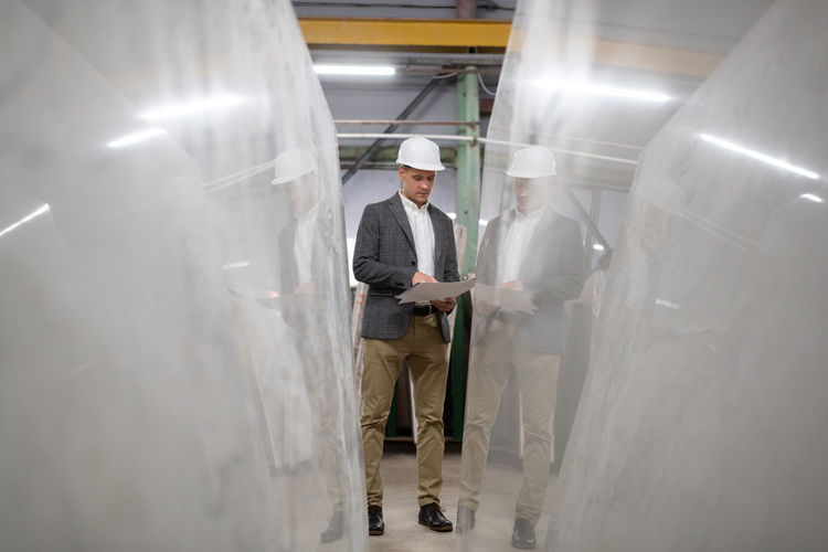 Male architect examining blueprint near marble