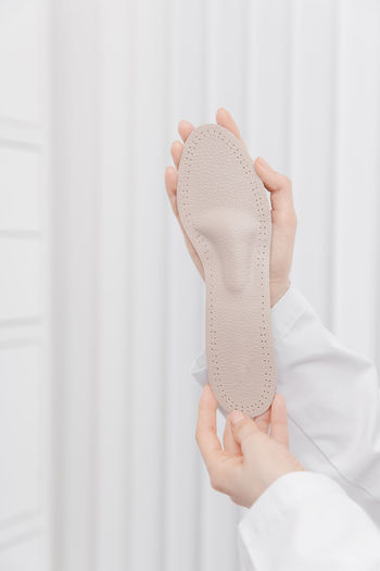 Cropped hand of woman holding insole