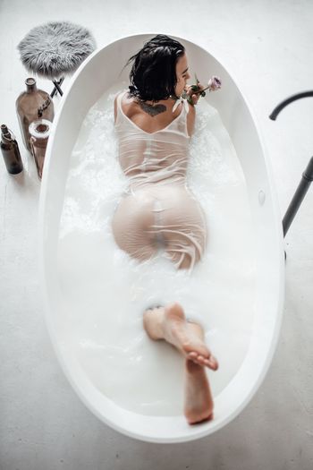 High angle view of woman lying in bathtub