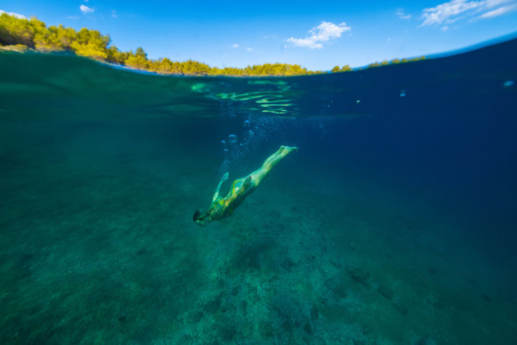 Girl diving in the adriatic sea on hvar island, croatia