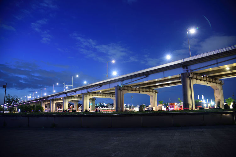 Illuminated bridge against sky at night