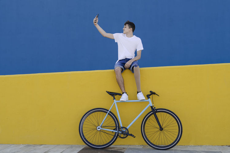 Full length of a bicycle against yellow wall