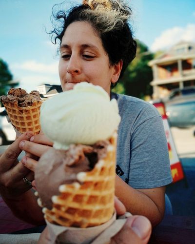 Woman holding ice cream in city
