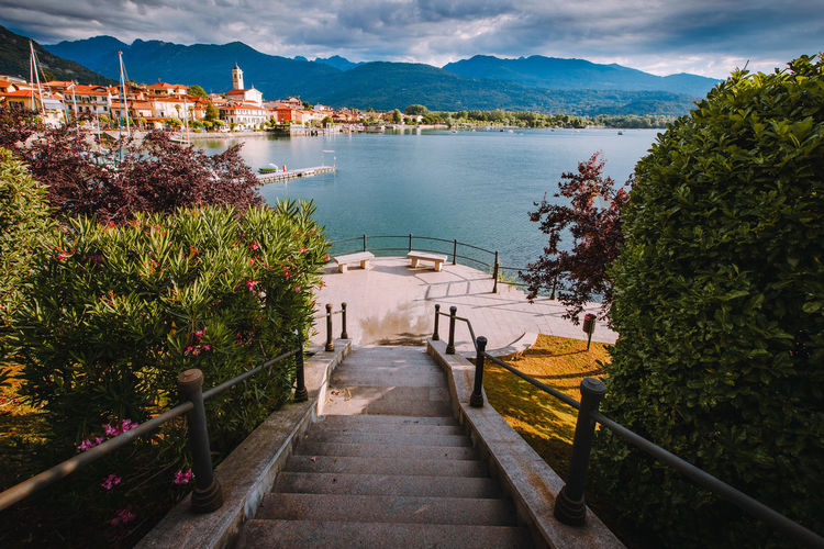Feriolo village on lake maggiore with cloudy sky and steps to walk along the lake in the foreground