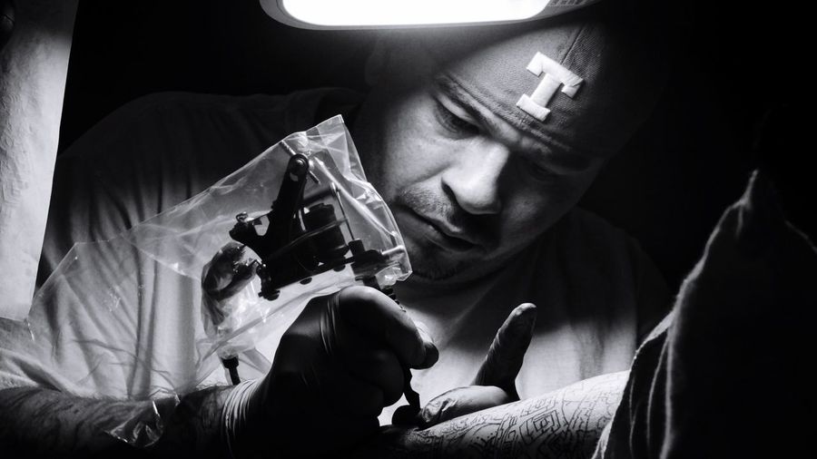 Artist making tattoo on person