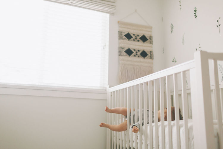 Baby boy lying in crib at home