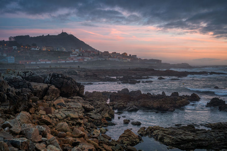 A guarda beautiful sea landscape rock beach with city on the foreground at sunset, in spain