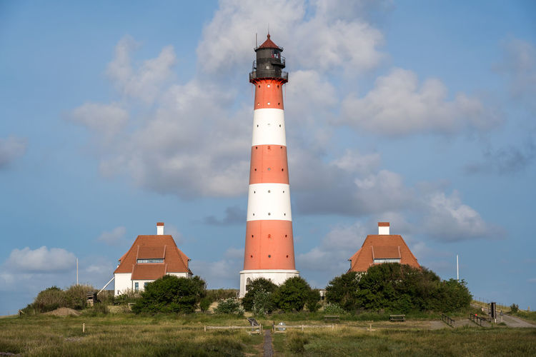 Low angle view of lighthouse amidst buildings against sky
