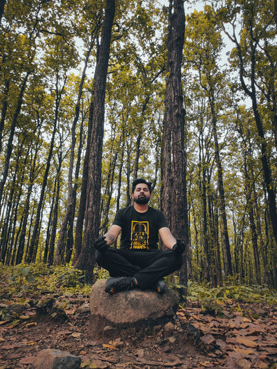 Portrait of young man sitting in forest