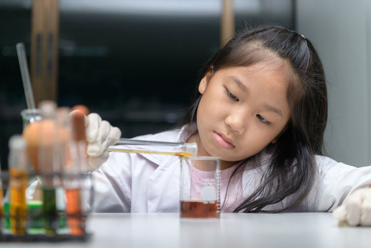 Girl experimenting with chemical at laboratory in school