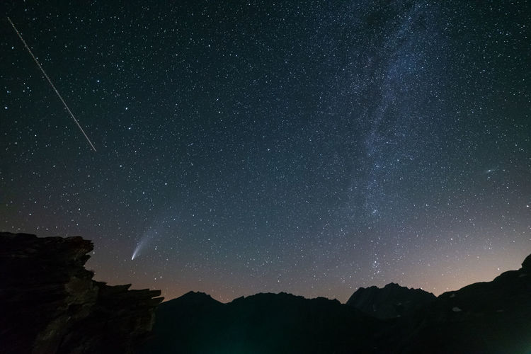 Low angle view of silhouette mountain against sky at night