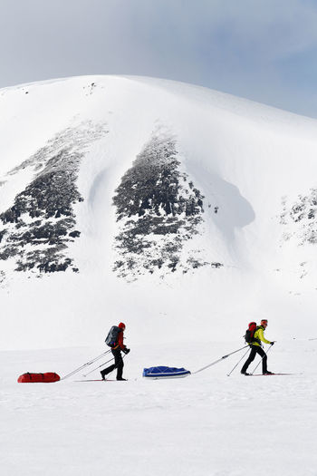 People skiing on snowcapped mountains during winter