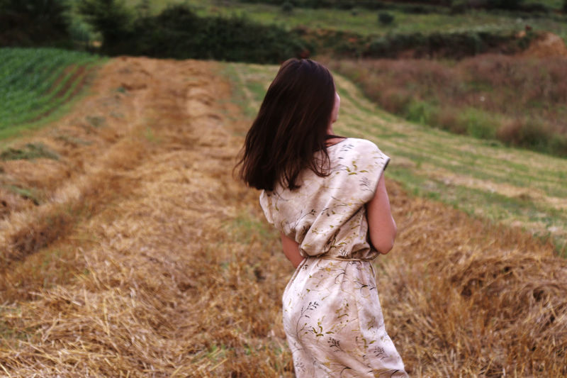 Rear view of woman standing on field