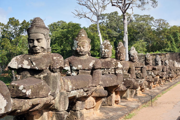 Statues against trees and temple