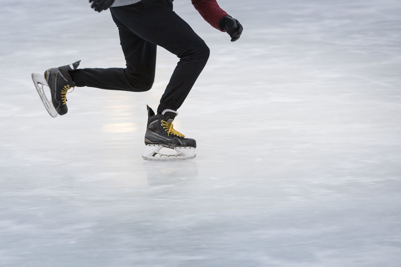 Low section of man ice-skating on rink