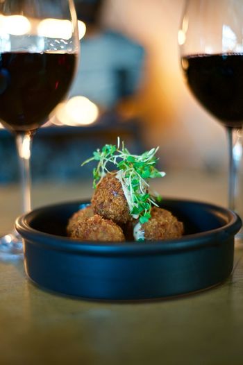 Close-up of arancini served with red wine on table