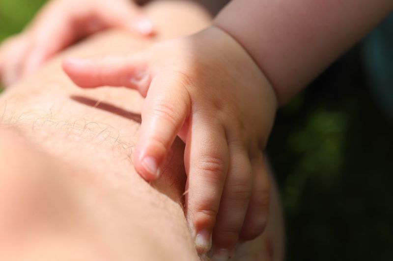 Close-up of baby hands touching leg