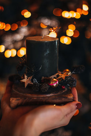 Cropped hand of woman holding lit candle