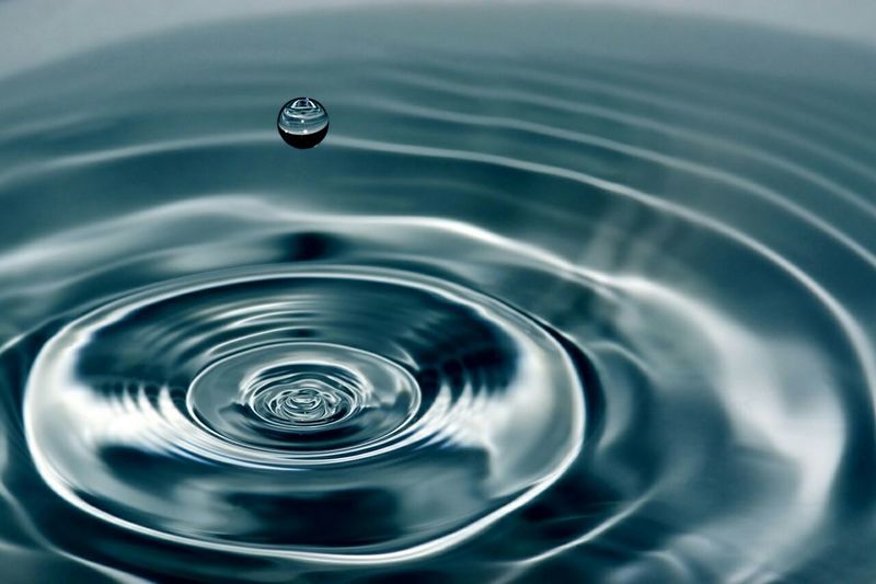 Close-up of drop on blue rippled water