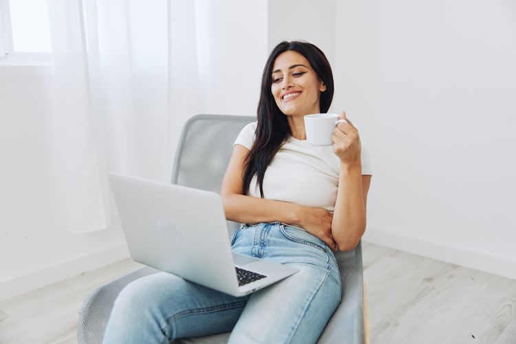 Portrait of young woman using laptop at home