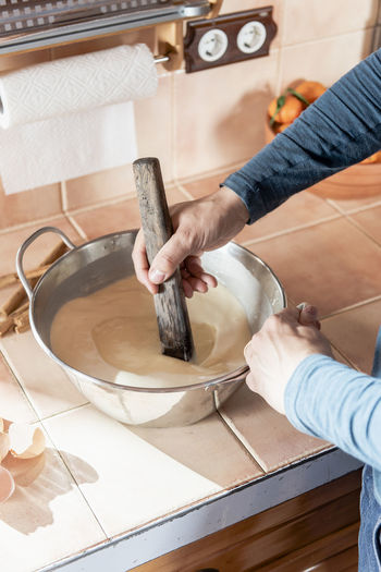Close up of middle aged man hands mixing ingredients in dough.