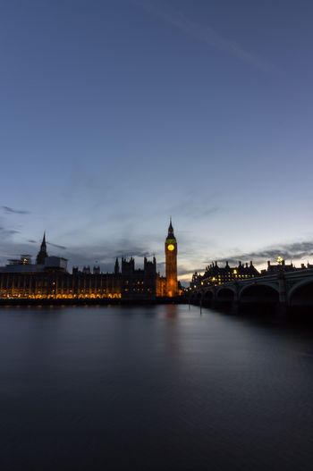 Illuminated big bien by thames river against sky