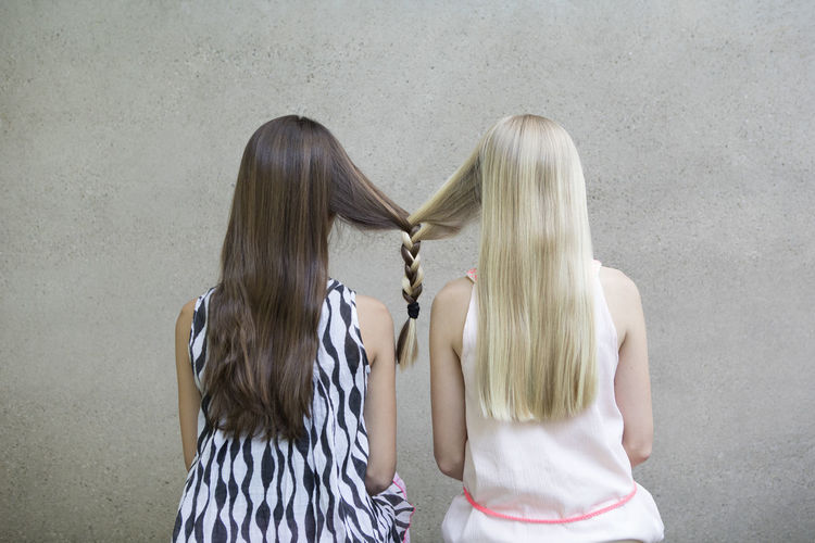 Back view of two long-haired girls with one braid