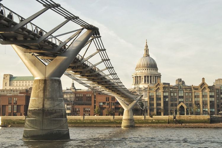 Millennium bridge over thames river against st paul cathedral