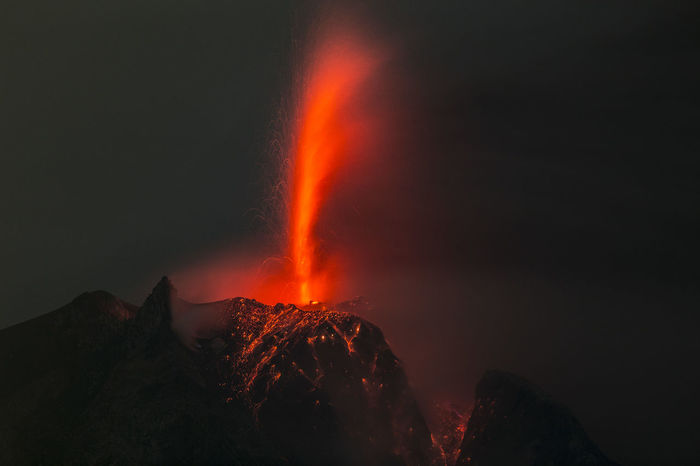 Lava erupting from mountain at night