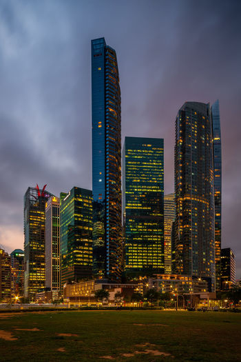 Illuminated buildings in city against sky at dusk