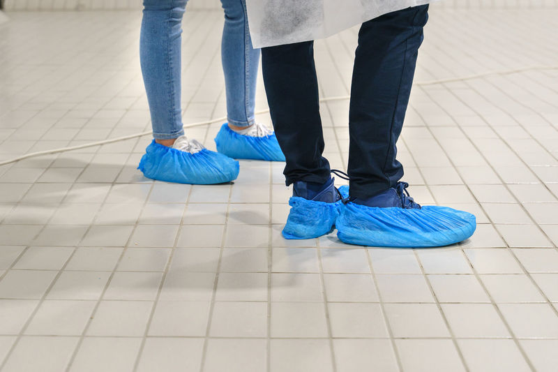 Low section of people standing on tiled floor