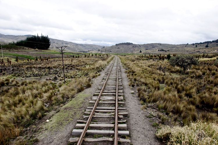 Railroad tracks on field against sky
