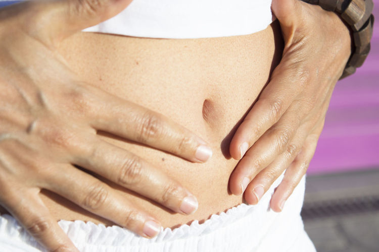 Flat stomach of woman health symptom on hands