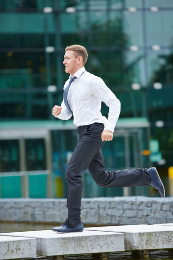 Side view of businessman running at park